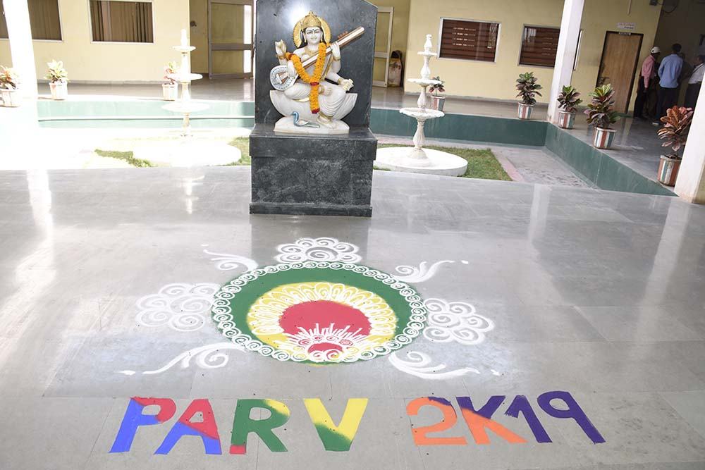 Rangoli reading PARV 2K19 beside a statue