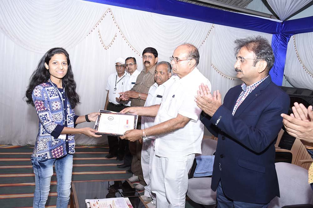 A student receiving a certificate at the Annual Social Gathering and Prize Distribution Function